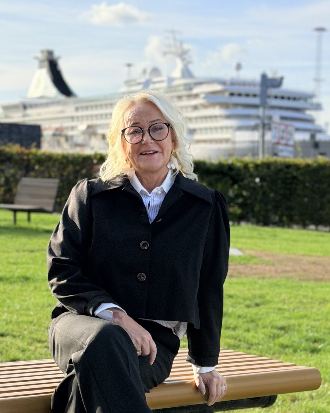 Torun Nordskaug sitter på en benk ved havnen og ser i kameraet